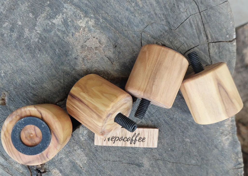 A set of wooden feet replacements for a Lelit Bianca coffee machine, displayed on a wooden surface.